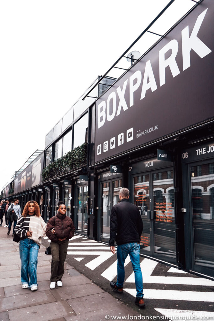 Guide to visiting Boxpark Shoreditch in London. Everything from food, apparel, events, and how to get there. Plus why you should miss it. | Box Park Shoreditch | Boxpark Shoreditch Events | Boxpark Shoreditch Tickets | Black Bear Burger Shoreditch | Boxpark Shoreditch Drinks | Argentinian Grill Boxpark Shoreditch | Rudies Jerk Shack Shoreditch | Boxpark Restaurants Shoreditch | Boxpark Shoreditch London | Boxpark Shoreditch Food | Street Food Shoreditch | Shoreditch Street Food Market